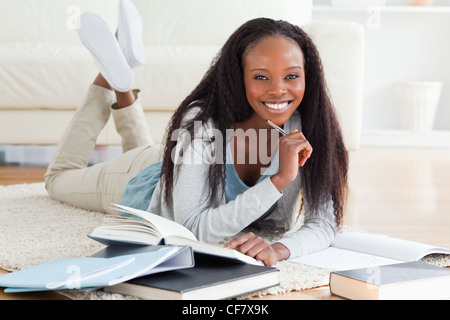 Studentin am Teppich Hausaufgaben liegen Stockfoto
