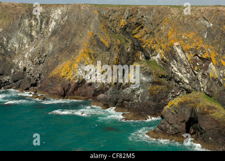 Wellen sanft gegen die Felsen brechen und Höhleneingang in der Nähe von Soap-Rock auf dem South West Coast Path zwischen Pfosten und Kynance Stockfoto