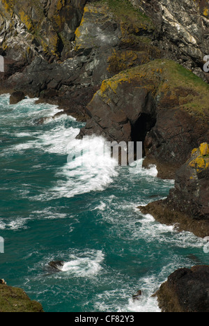 Wellen sanft gegen die Felsen brechen und Höhleneingang in der Nähe von Soap-Rock auf dem South West Coast Path zwischen Pfosten und Kynance Stockfoto