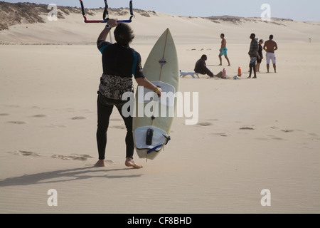 Rabil Boa Vista Kapverdische Inseln Mann im Neoprenanzug hält Kite Trapez Surfbrett auf unberührten unberührte Strand von Areja de Chaves Stockfoto