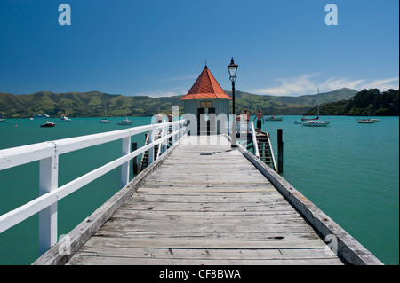 Blick entlang der hölzernen Pier in Akaroa Harbour, Neuseeland Stockfoto
