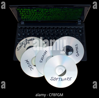 Piraterie-Konzept - gebrannte CDs mit illegaler Software auf Tastatur von Notebook - auf schwarzem Hintergrund isoliert Stockfoto