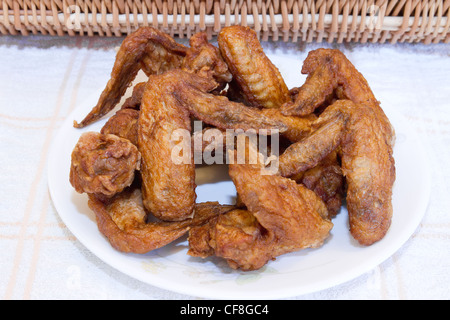 Platte von Deep Fried Chicken Wings mit Picknick-Korb Stockfoto