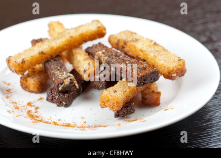 Zwieback mit Knoblauch auf einem Teller auf hölzernen Hintergrund Stockfoto