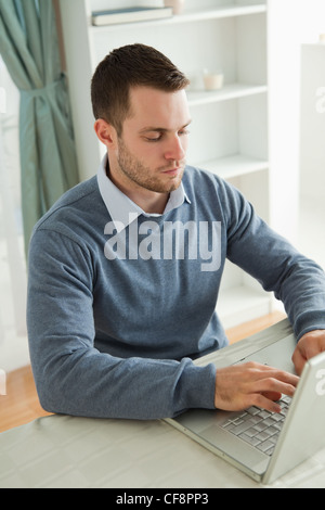 Geschäftsmann, die Eingabe auf seinem Laptop in seinem homeoffice Stockfoto
