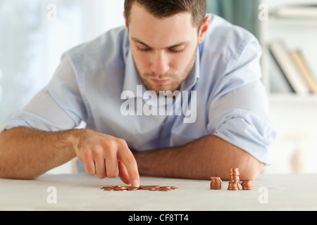 Geschäftsmann, seine kleine Münzen zählen Stockfoto