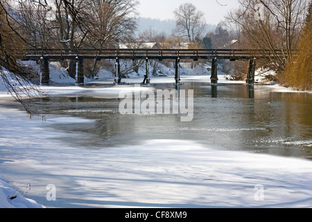 Teilweise zugefrorenen Fluss mit alte Holzbrücke im Hintergrund. Stockfoto