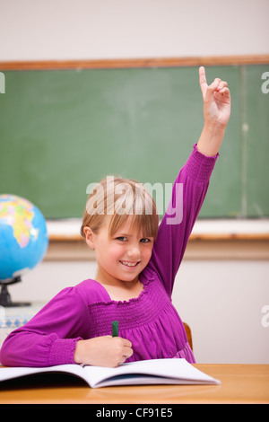 Porträt einer Schülerin, die ihre Hand heben Stockfoto