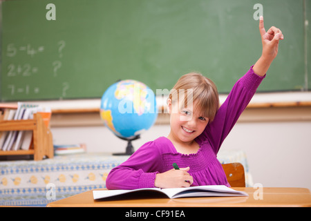 Schulmädchen hob ihre Hand eine Frage stellen Stockfoto