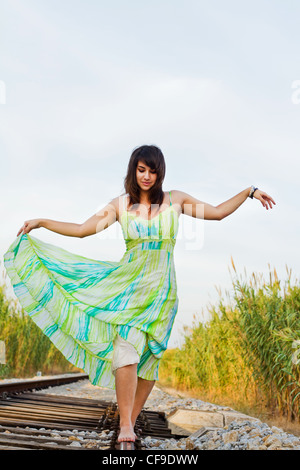 Blick auf ein schönes Mädchen mit einem Frühling Kleid auf einer Eisenbahn. Stockfoto