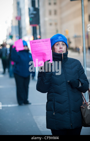 Hunderte von Freiwilligen mit symbolischen "Pink Slips" Linie Broadway in Lower Manhattan in New York Stockfoto