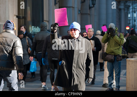 Hunderte von Freiwilligen mit symbolischen "Pink Slips" Linie Broadway in Lower Manhattan in New York Stockfoto