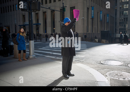 Hunderte von Freiwilligen mit symbolischen "Pink Slips" Linie Broadway in Lower Manhattan in New York Stockfoto