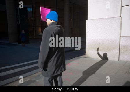 Hunderte von Freiwilligen mit symbolischen "Pink Slips" Linie Broadway in Lower Manhattan in New York Stockfoto