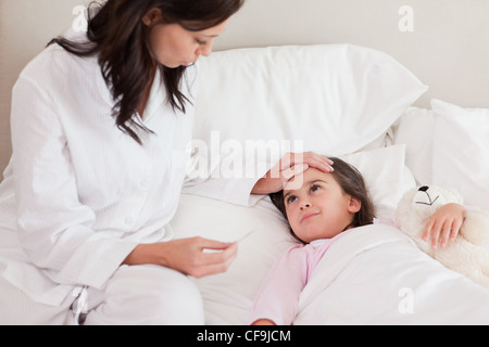 Mutter, die Kontrolle über ihre Tochter Temperatur Stockfoto