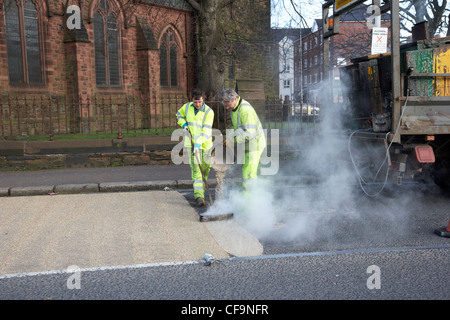 Arbeiter installieren heißen angewandte hohe Reibung Straßenbelag Belfast Nordirland Vereinigtes Königreich Stockfoto
