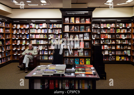 Ein Mann sitzen Lesung in einem Buchladen Waterstones, Cambridge UK Stockfoto