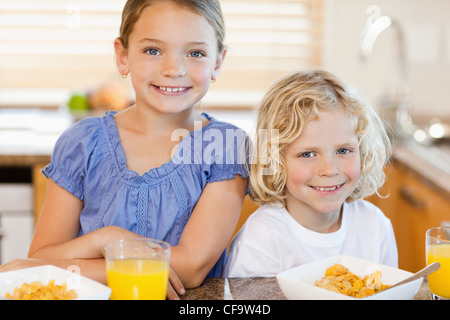 Bruder und Schwester mit Frühstück in der Küche Stockfoto