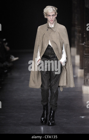 Ann Demeulemeester Paris bereit, tragen Menswear Herbst Winter braun Cape Mantel, weißes Hemd, Hose Schwarzgurt Kohle und Stockfoto