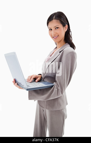 Seitenansicht des lächelnden Geschäftsfrau stehend mit laptop Stockfoto