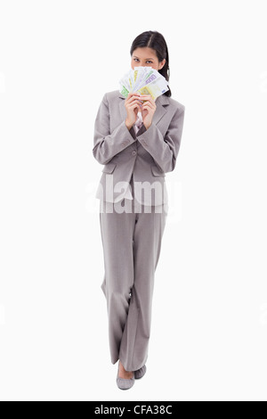 Geschäftsfrau Gesicht hinter Banknoten versteckt Stockfoto