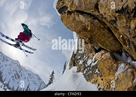 Eine Skifahrerin fliegt von einer Klippe am Kicking Horse Resort, Golden, BC Stockfoto