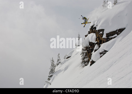 Ein männlicher Skifahrer Tropfen eine Klippe, Kicking Horse Backcountry, Golden, BC Stockfoto