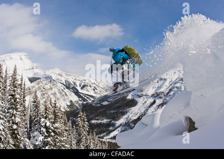 Ein männlicher Skifahrer fängt etwas Luft im Sunshine Village Hinterland, Banff, AB Stockfoto