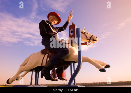 Ältere Frau mechanische Reitpferd Cowboy Kostüm, Kanada. Stockfoto