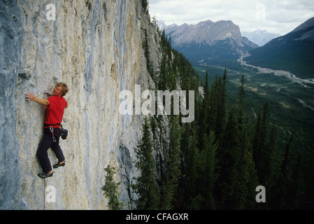 ein junger Mann im Vorfeld einer Route genannt Weapons of Mass Destruction in Spray-Seen, Alberta, Kanada. Stockfoto