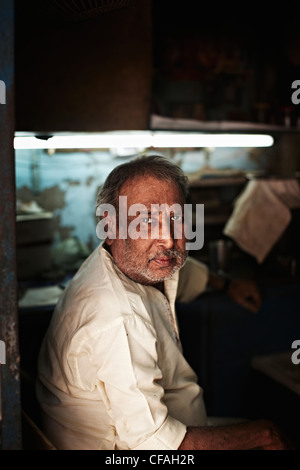 Im mittleren Alter Mann sitzt im shop Stockfoto