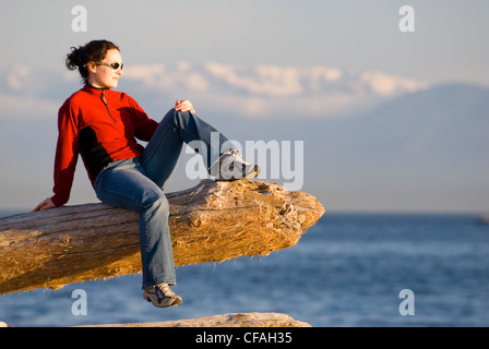 Eine Frau, die Aussicht entlang der Uferpromenade Dallas Road in Victoria, Vancouver Island, British Columbia, Kanada. Stockfoto