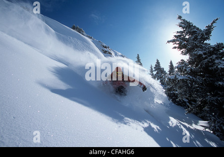 Mann, Snowboarden im Sonnenschein Dorf Hinterland, Alberta, Kanada. Stockfoto