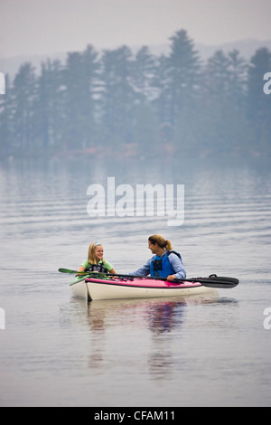 Young/mittlerem-aged Mutter und Tochter Seekajak auf Quelle See, Algonquin Provincial Park, Ontario, Kanada. Stockfoto