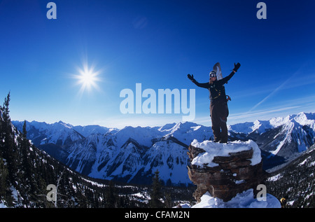 Snowboarder stehen auf Felsen mit Blick auf die Bergkette im Hinterland der Provinz Alberta, Kanada. Stockfoto