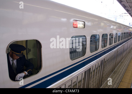 Dirigenten überprüft seine Uhr, wie seine Shinkansen für Shin-Osaka, Japan zu verlassen soll. Stockfoto