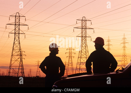 Arbeitnehmerinnen und Arbeitnehmer in der Nähe von elektrischen towers(pylons) in der Nähe von Winnipeg, Manitoba, Kanada Stockfoto