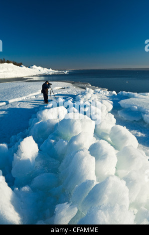 ein Fotograf macht Fotos von angespült Eis Pfähle, entlang Lake Winnipeg, Manitoba, Kanada Stockfoto