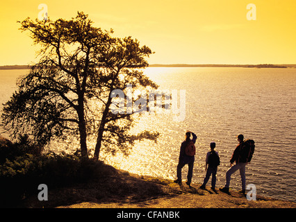 Familie Wandern entlang der Klippe genießen den Blick auf den Sonnenuntergang, Big Nutimik Lake, Whiteshell Provincial Park, Manitoba, Kanada Stockfoto