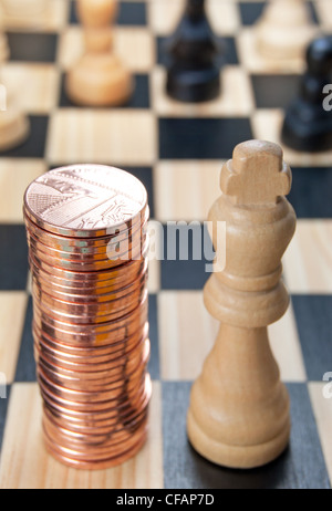 Stapeln von Münzen als nächstes zu einem Schachkönig Stück Stockfoto