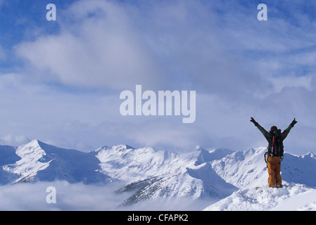 Ein Skifahrer genießen den Blick auf die verschneiten Berggipfel im Hinterland, Purcell Range, Golden, British Columbia, Kanada Stockfoto