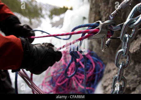 Nahaufnahme von einem Eiskletterer sichern Seil auf Wicked Wanda WI 4, Ghost River, Ausläufer, Rocky Mountains, Alberta, Kanada Stockfoto