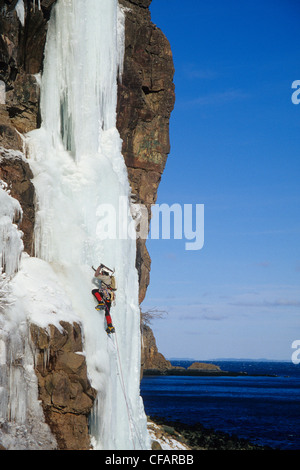 Ein Eiskletterer auf seinem Weg von Wiser Deluxe WI 5, Grand Manan Island, New Brunswick, Kanada Stockfoto