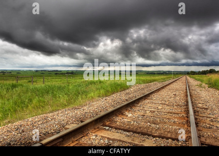 Railroad tracks mit Wolken im Hintergrund in der Nähe von Didsbury, Alberta, Kanada Stockfoto