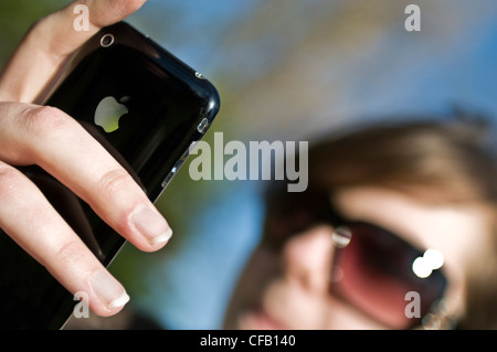 Eine junge Frau mit ihrem iphone Stockfoto