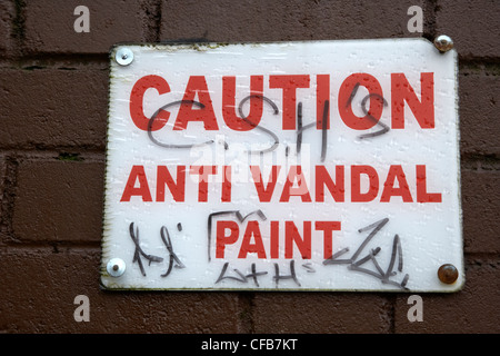 geschändeter Vorsicht Anti-Vandal Farbe Zeichen an der Wand in Belfast Nordirland Vereinigtes Königreich Stockfoto