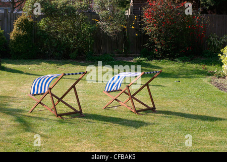 Vororte von London: zwei leeren blaue-weiße gestreifte Liegestühlen im Gardenon Rasen Stockfoto