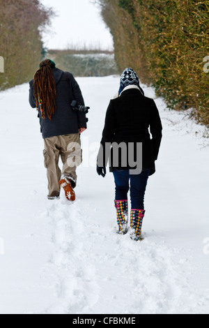 Junger Mann mit Dreadlocks und eine Frau, Wandern im Schnee Stockfoto