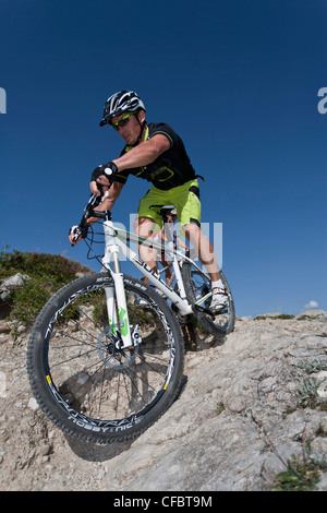 Biken, Extreme, Biker, Biker, Go, steile, steile Felsen, Klippen hinunter, Alpenkulisse, sport, Fahrrad, von unten, Dynamik, E Stockfoto