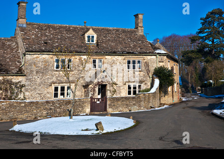 Einen hübschen Cotswold Steinhaus im Schnee bei Ampney St Peter, Gloucestershire, England, UK Stockfoto